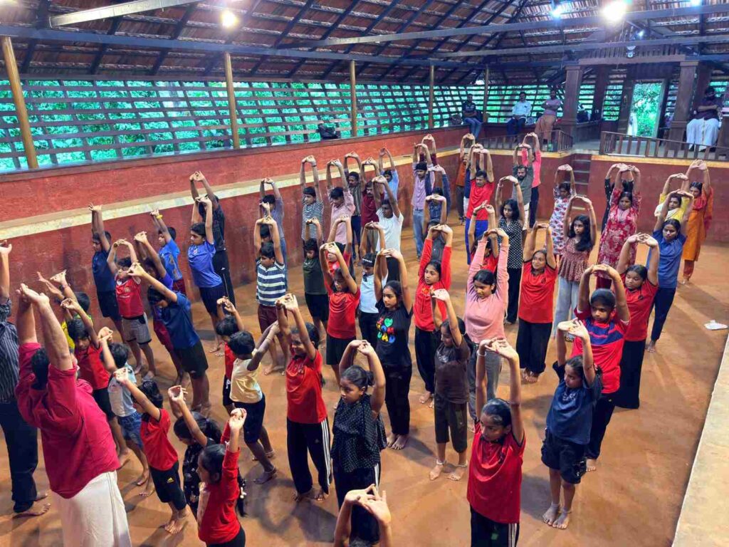 Expert instructors demonstrating Kalaripayattu and Yoga wellness techniques to students.